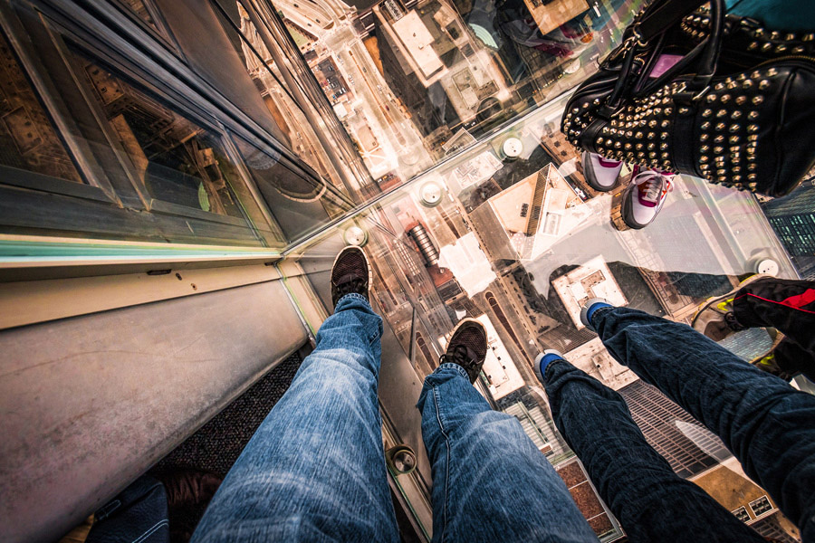 people looking down from glass elevator 