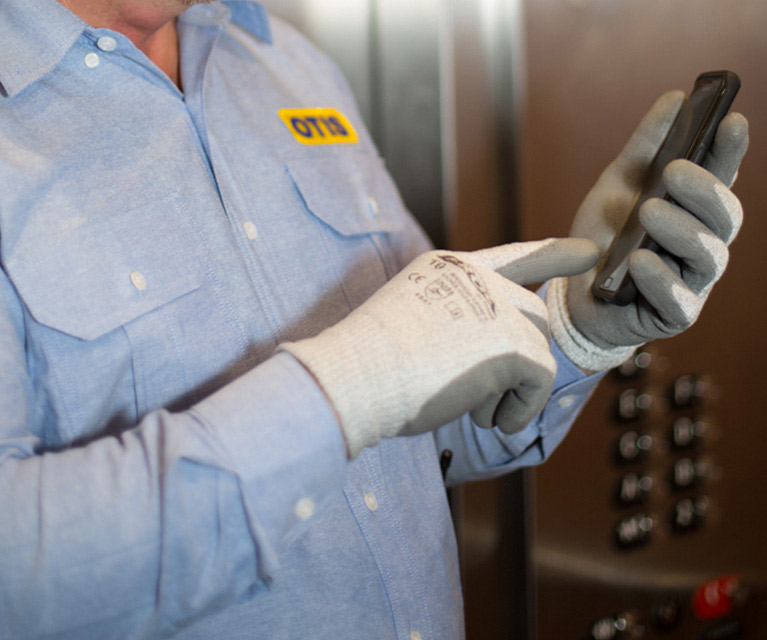 worker with hand gloves operating mobile 