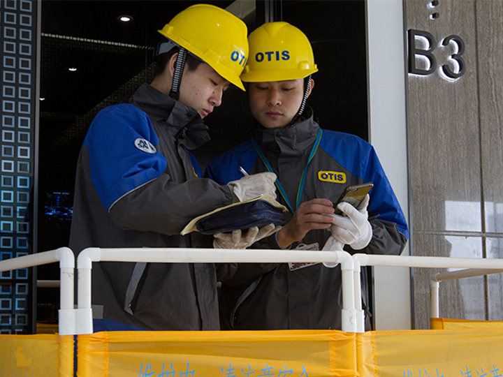 engineers with hat one is holding phone and another writing 