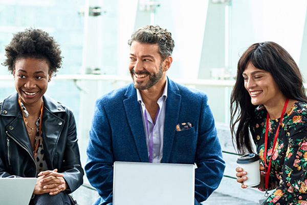 three colleagues smiling while working