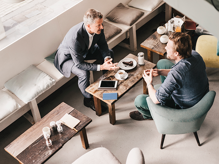 Aerial view of two men meeting over coffee