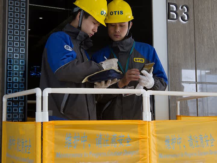 Two people reviewing the work at an elevator floor