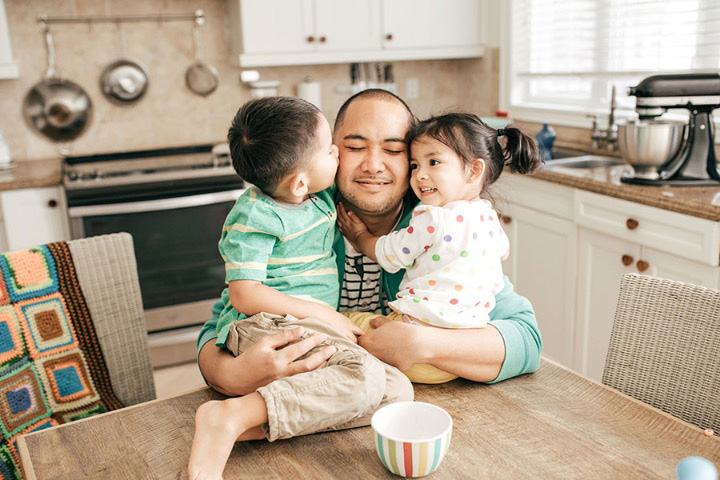 father-hugging-children-in-kitchen