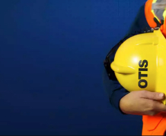 Mechanic holding protective helmet at side