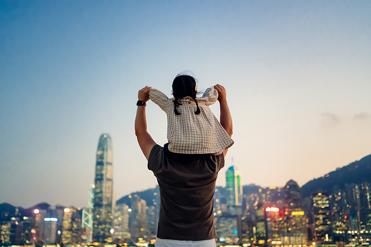 Little girl on top of Father's shoulders looking at a skyline