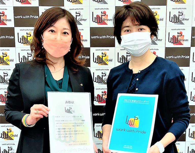 Two women from Nippon Otis holding award
