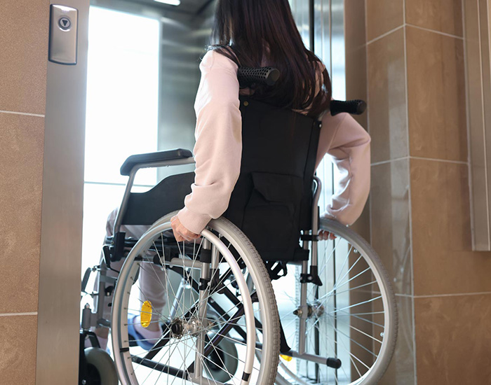 woman in a wheelchair entering an elevator
