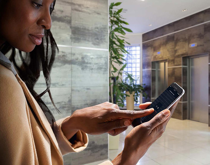 Woman using her phone near an elevator