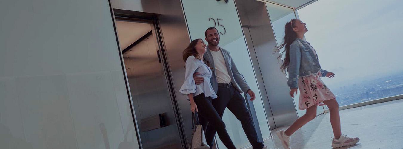 people smiling as they walk out of an elevator