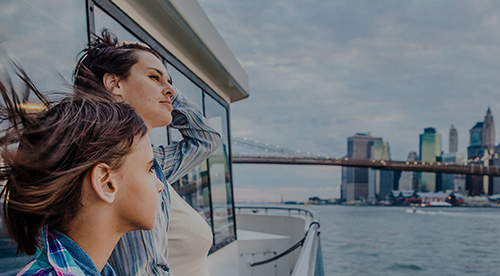 Woman and boy looking at city skyline from a ferry boat