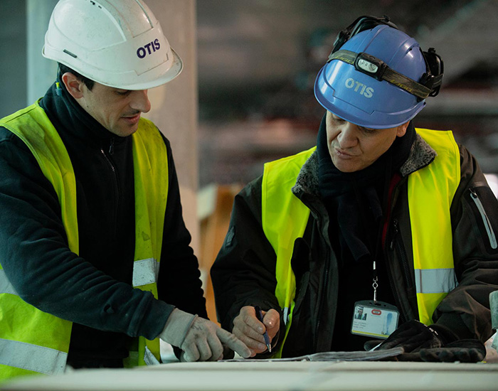 Two Otis technicians working on a job
