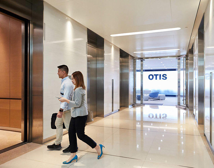 Two people walking into an elevator