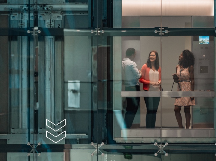 Three people in a glass elevator