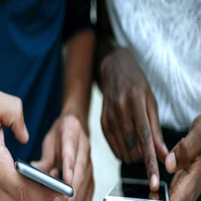 men's hands using cell phone