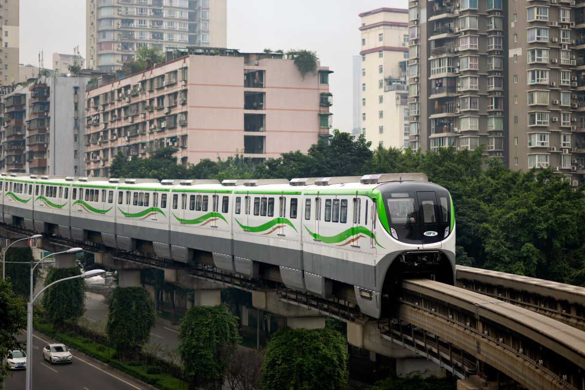 Chongqing metro train pulling around curve in city 