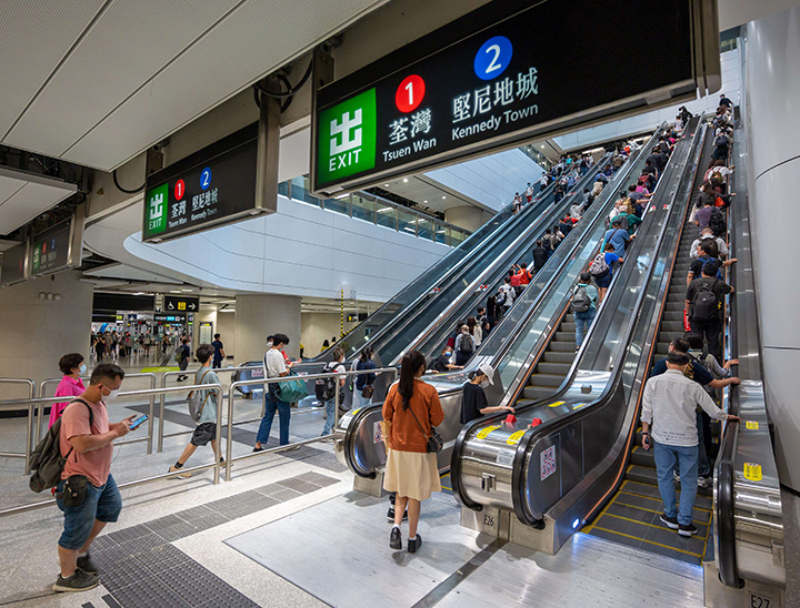 people walking towards escalator