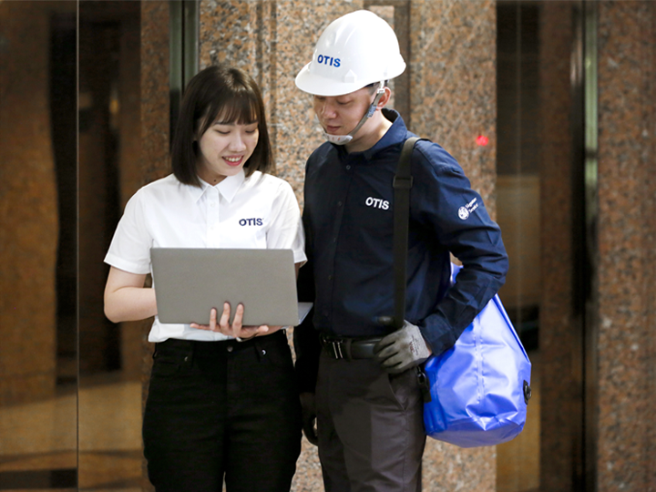 lady holding laptop and man looking at laptop screen