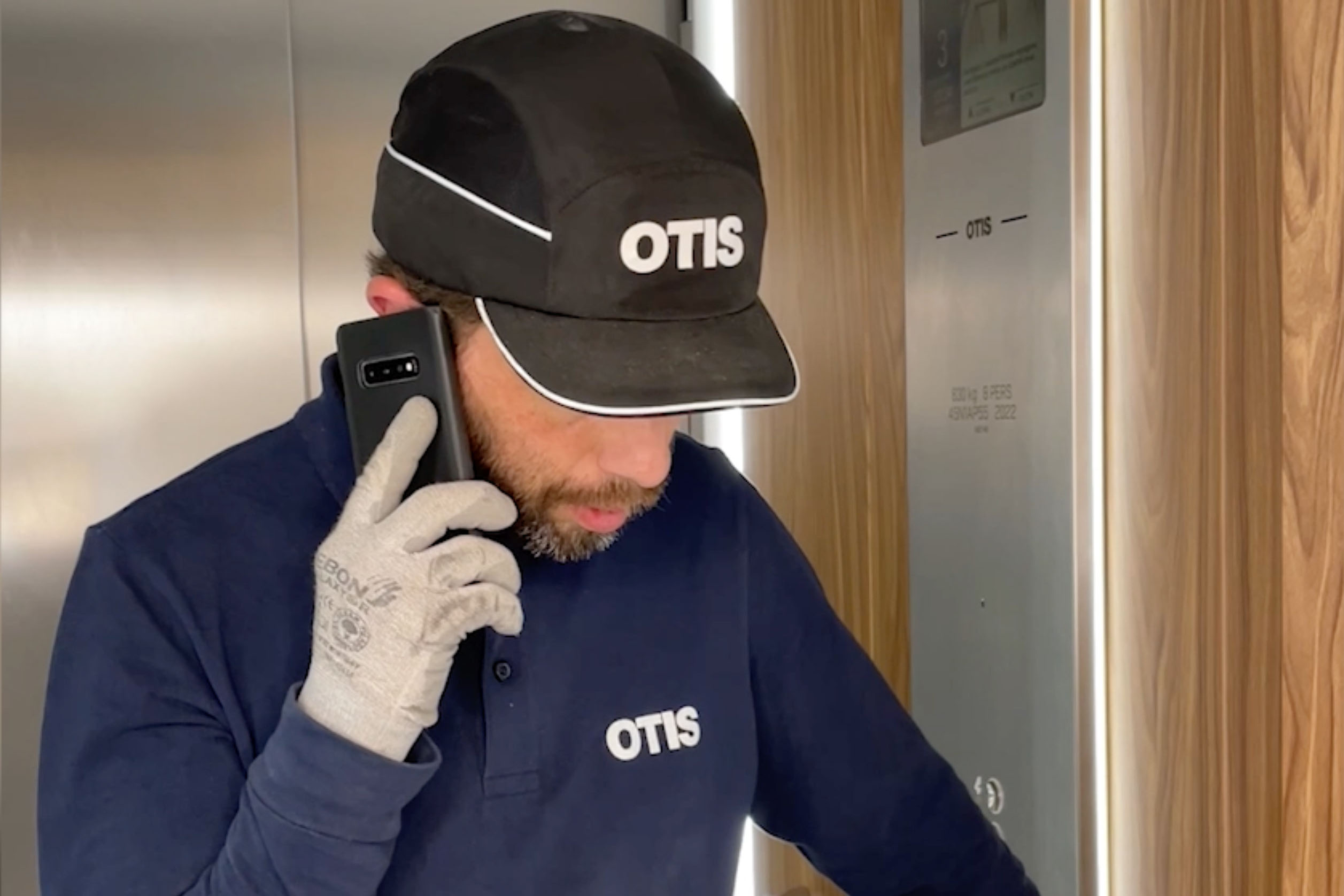 Otis employee Franck on mobile phone inside an elevator
