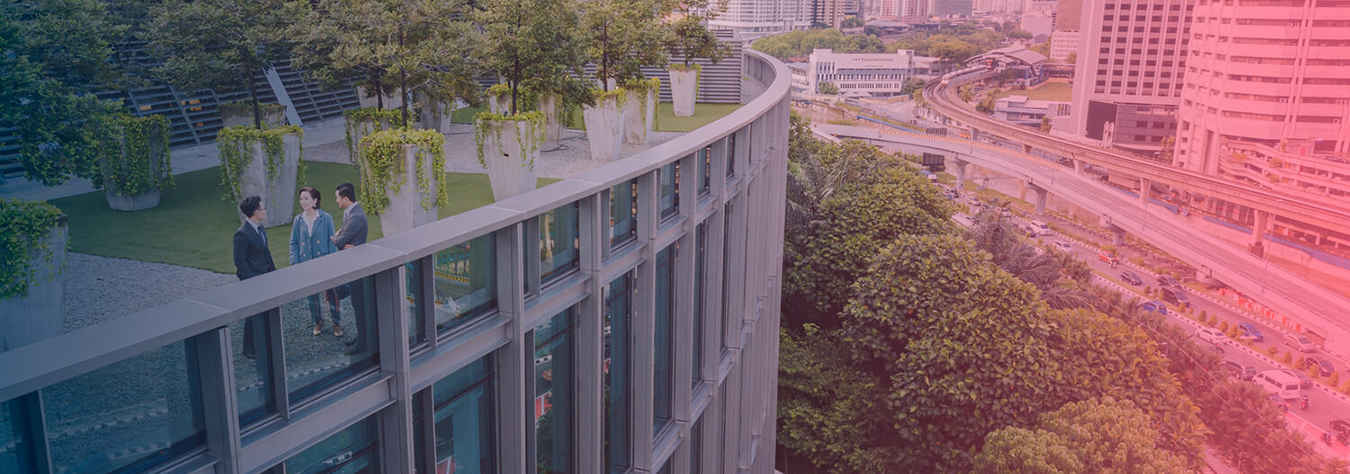 Three people talking at the roof patio of a tall building