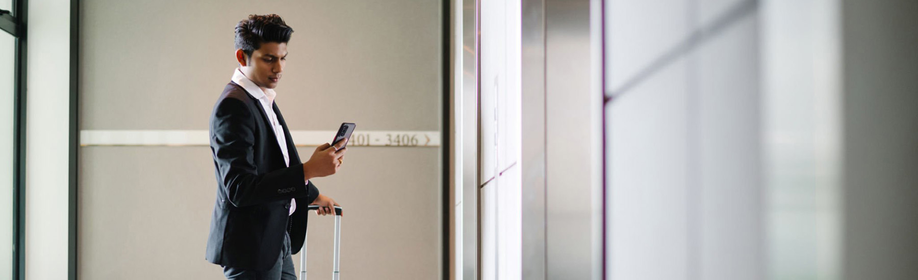 Man looking at phone while waiting for elevator