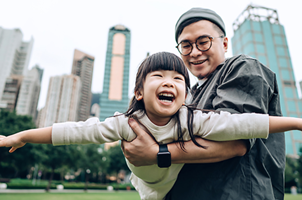 Father swinging daughter in airplane position