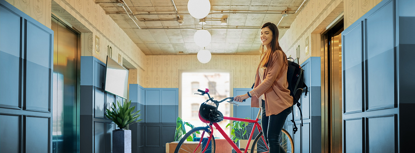 Woman walking her bike out of an elevator