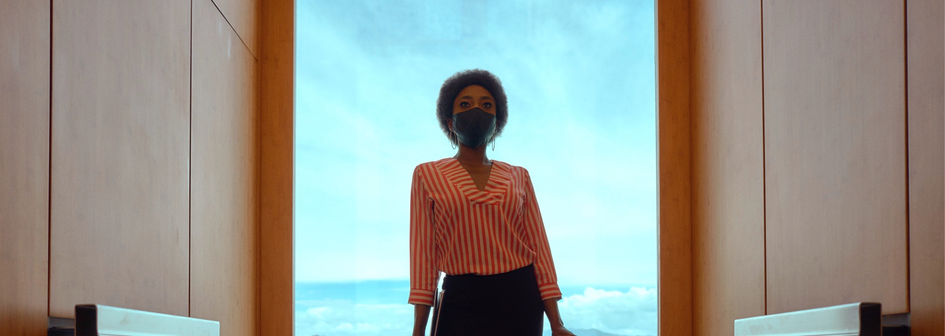 Woman in elevator with mask