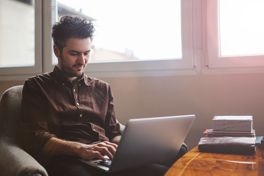 man at home studying on laptop