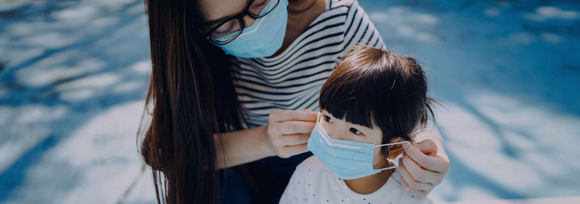 Mother wearing a mask to her daughter