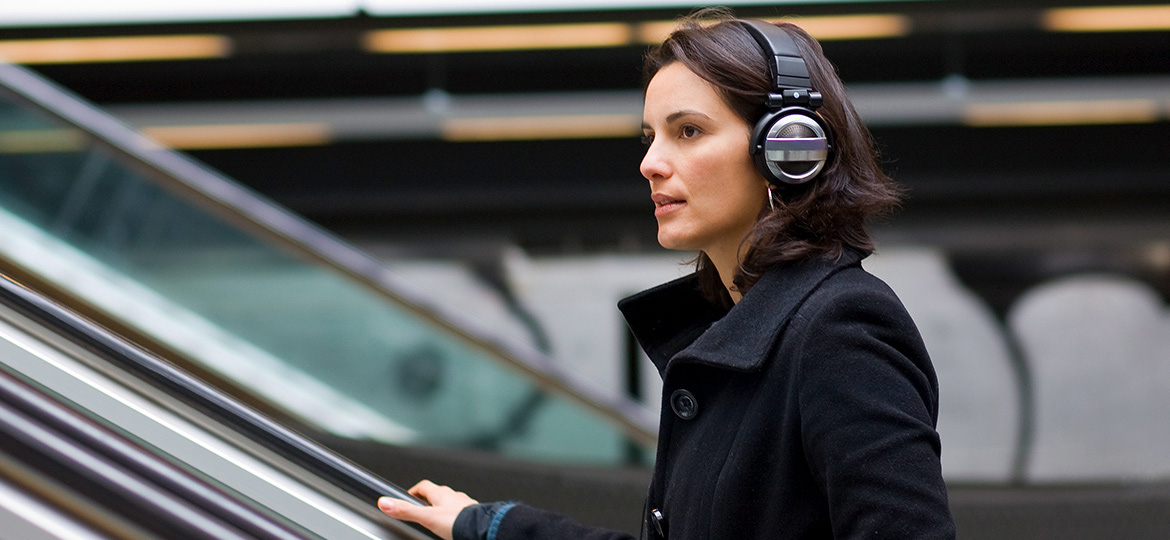 young woman with headphones on escalator