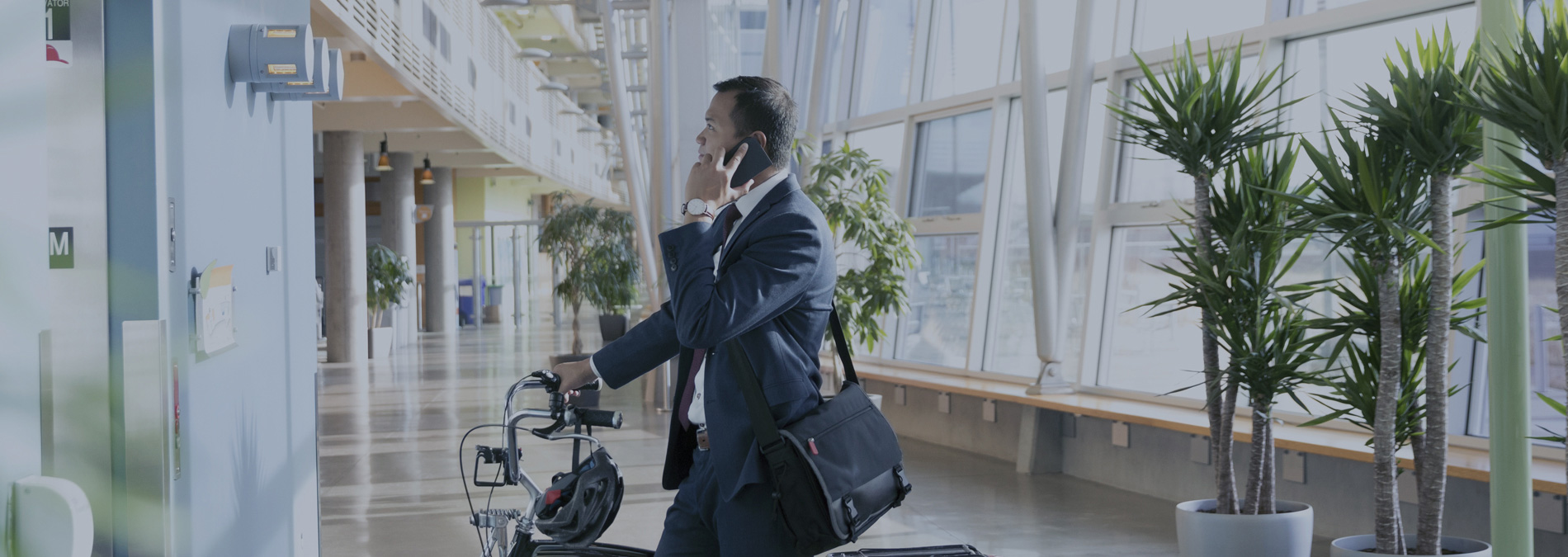 man talking on phone while holding bicycle 