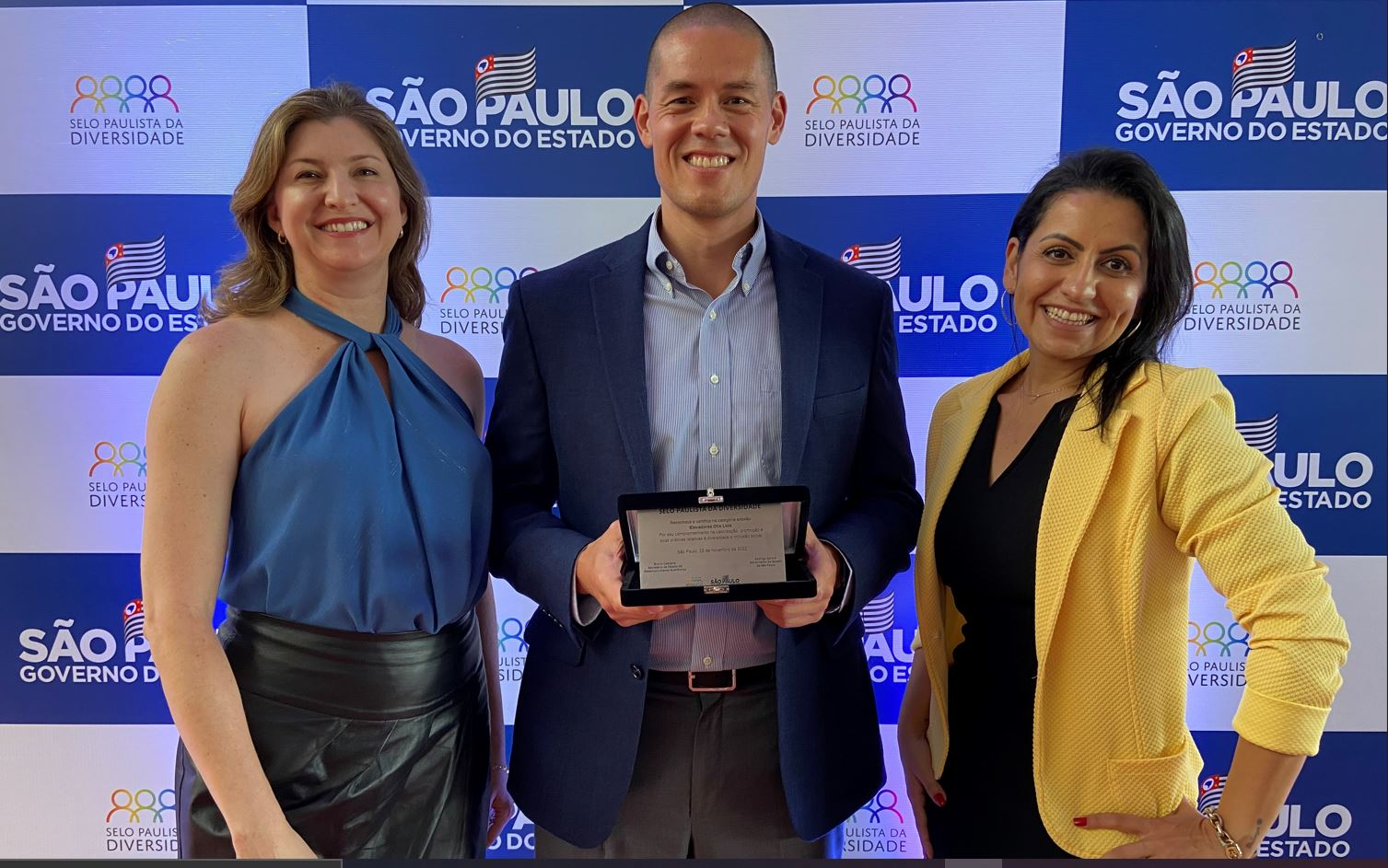 employees smiling and posing with award winner